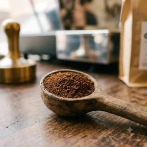 Close-up view of the fine, powdery texture of ground coffee for espresso machine resting on a spoon.